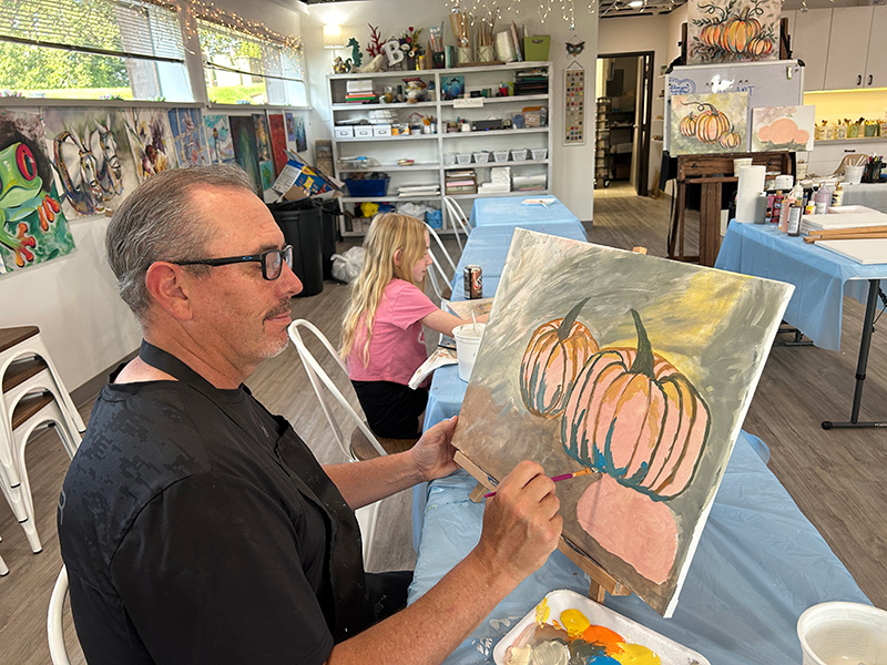 Student and pumpkin painting